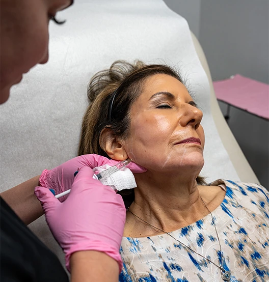Mystique provider injecting filler in patient's jaw area